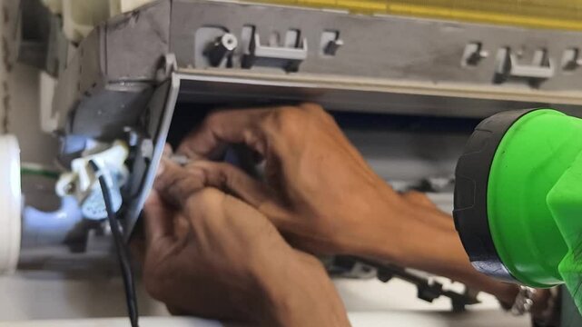 A technician repairs a wall mounted air conditioner and fixing HVAC systems