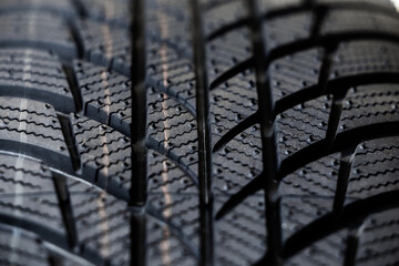 Winter tyres detail. Macro shot of a tire tread, highlighting deep grooves and intricate patterns...