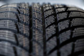 Winter tyres detail. Macro shot of a tire tread, highlighting deep grooves and intricate patterns...