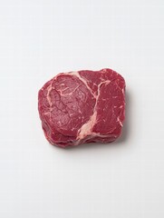 Obraz premium A single piece of raw meat sitting on a clean white surface ready for cooking and preparation