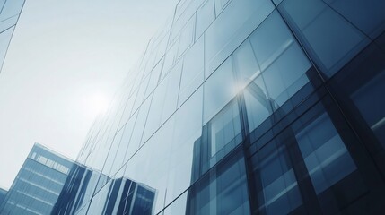Modern glass building facade with blue reflections in the daytime sky view from below