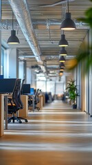 Very long office space featuring rows of desks and workstations for multiple employees in action