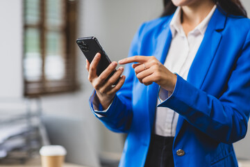 Businesswoman using mobile phone and sending messages online on smartphone.