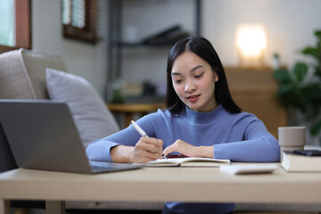Serious young Asian woman is bored from working at home.
