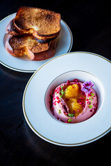 Deliciously vibrant beetroot hummus garnished with fruits, paired with crispy toasted bread