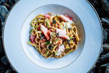 Linguine pasta is adorned with fresh seafood, herbs, and a hint of luxury in a stylish presentation