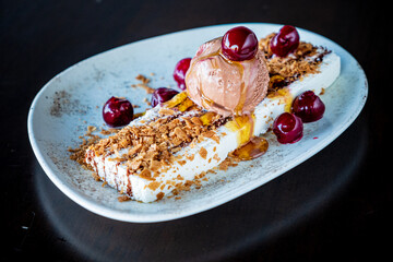 A festive dessert showcases creamy ice cream crowned with sweet cherries, perfect for celebration
