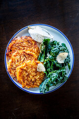 Crispy potato patties with fresh greens and a creamy dip create a colorful, tasty dish