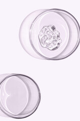 A sample of skin serum or moisturizing gel in a Petri dish. A cosmetic product.