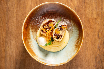 A stunning dessert features flaky pastry filled with fruit and chocolate on a creamy base