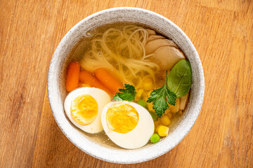 A satisfying bowl of noodle soup with fresh veggies, tasty broth, and a soft boiled egg
