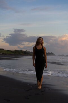Beautiful woman in long dress on the beach at sunset. Bali