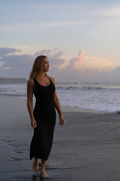 Beautiful woman in long dress on the beach at sunset. Bali
