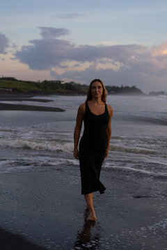 Beautiful woman in long dress on the beach at sunset. Bali