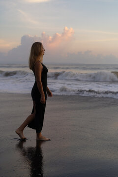 Beautiful woman in long dress on the beach at sunset. Bali