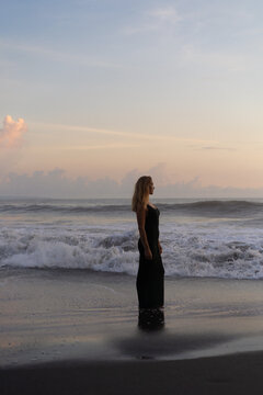 Beautiful woman in long dress on the beach at sunset. Bali