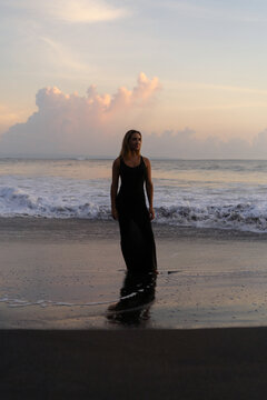Beautiful woman in long dress on the beach at sunset. Bali