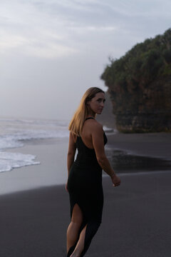 Beautiful woman in long dress on the beach at sunset. Bali