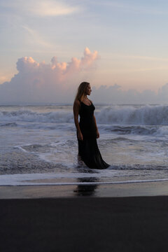 Beautiful woman in long dress on the beach at sunset. Bali