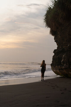 Beautiful woman in long dress on the beach at sunset. Bali