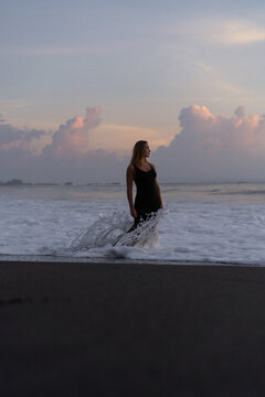 Beautiful woman in long dress on the beach at sunset. Bali