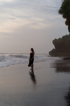 Beautiful woman in long dress on the beach at sunset. Bali