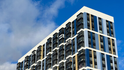 The facade of the building is purple,geometric patterns from windows and balconies, the colored wall of a modern multi-storey residential building, the abstract texture of the facade of the house