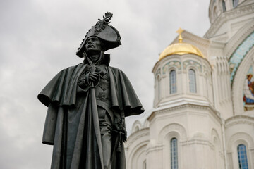 Monument to Admiral Fyodor Ushakov on the background of the Naval Cathedral of St. Nicholas the Wonderworker, Kotlin Island. Russia, Kronstadt, 7.07.2022