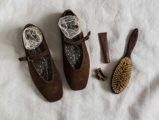Brown suede women's shoes, socks, comb, cosmetics on a light background, top view