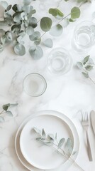 Elegant dining table setting with eucalyptus on marble surface