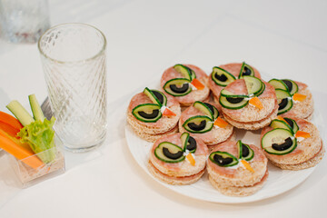 round kid sandwiches in the form of an owl on the served festive table