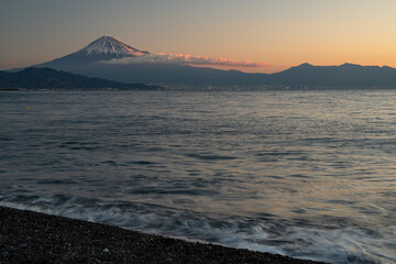 朝焼けの富士山を海岸から眺める