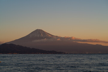 朝焼けの富士山を海岸から眺める