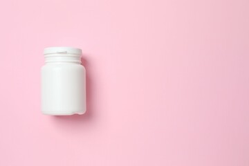 White bottle on pink background, top view