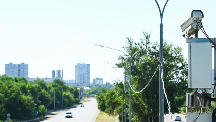 Security CCTV camera or surveillance system observes vehicular traffic on a road