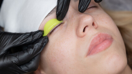 The master lays down the roller before the eyelash lamination procedure. 
