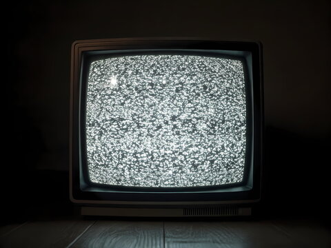Old analog television displaying static noise in a dark room