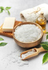 Magnesium flakes in a wooden bowl with soap, towel and essential oil creating a relaxing spa scene
