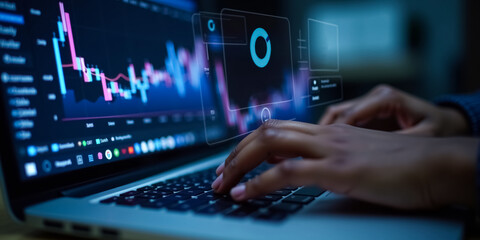 close-up of hands typing on a laptop displaying financial charts and graphs