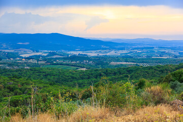 Tuscany, Borgo Scopeto, Italy - August 26, 2009: Picturesque evening view of hilly natural landscape and fields with vineyards in a valley near a small town Tuscany, Italy