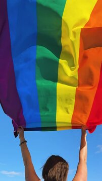 Gay pride parade, woman woman holding flag with rainbow lgbt flags