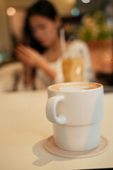 Cup of coffee. Girl on the background hold the phone