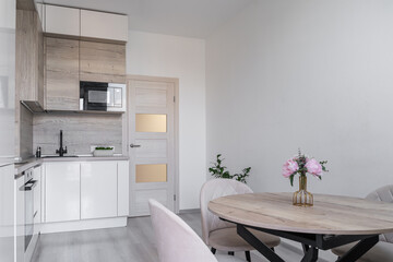Modern kitchen with cabinets and induction on counter, built-in oven, microwave. kitchen with white...