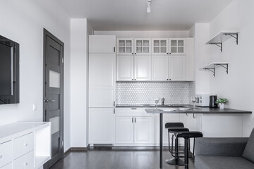 interior of modern apartment. design of built-in kitchen with white cabinets and black countertops....