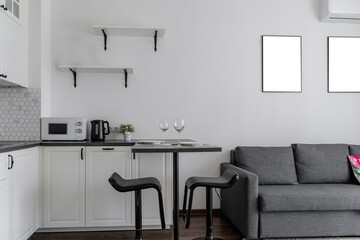interior of modern apartment. design of built-in kitchen with white cabinets and black countertops. kitchen is clean and bright. perfect order. minimalist kitchen design with cabinets and backsplash.