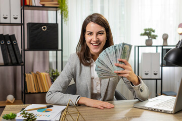 Smiling businesswoman counting cash money dollar checking salary enjoy richness at modern...
