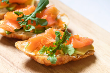 Smoked salmon with cream cheese and avocado slide on fresh croissants.
