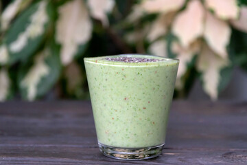 Healthy green kale smoothie greek yogurt with chia seeds in glass on wooden table background, top...