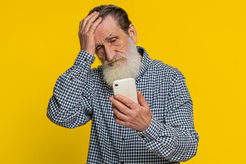 Upset sad senior man use smartphone typing browsing, play game, loses, surprised by sudden lottery...