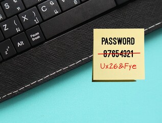 Keyboard on blue background with very weak and easy to guess password written on note - replaced to...
